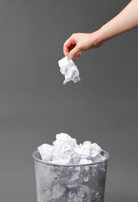 Putting crumpled paper in wastebasket